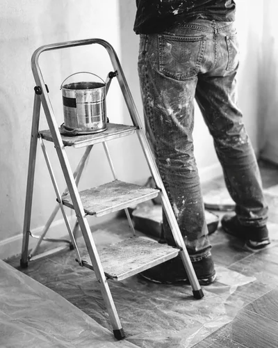 Pintor aplicando pintura en pared interior con rodillo